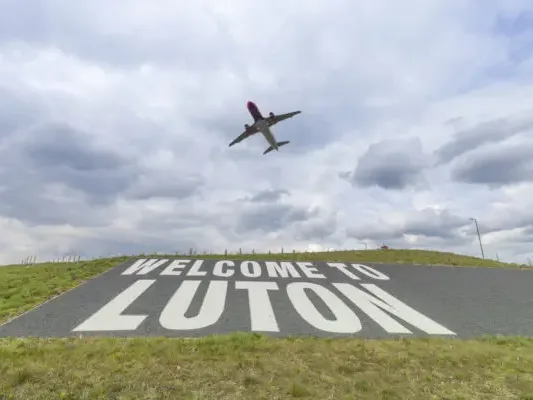 Welcome to Luton sign with a plane taking off from London Luton Airport - IT support in Luton and Dunstable from Total Group